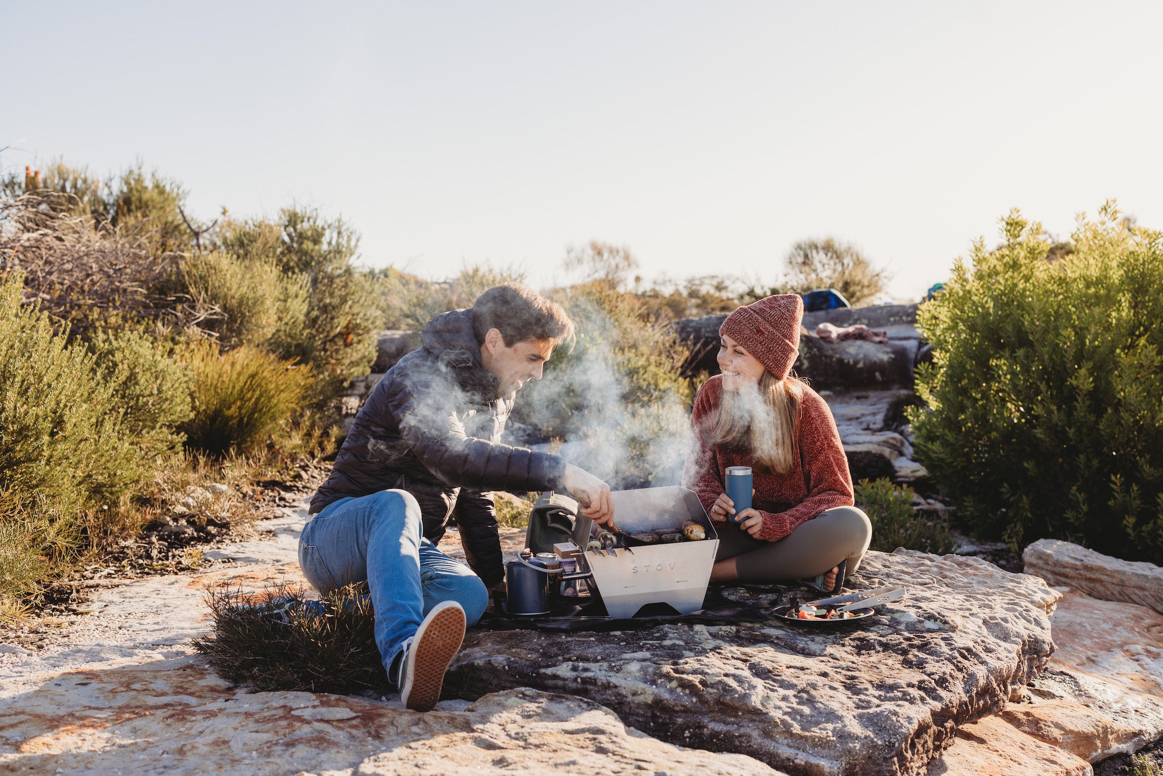 Couple grilling on the portable STOV Gas BBQ while out camping in nature