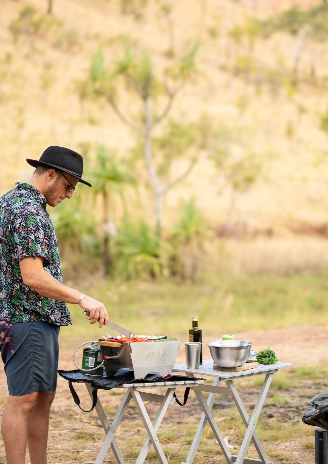 Cooking with a portable bbq on a clifftop or at the lake. The stov bbq is cooking delicious meals with ocean or lake views